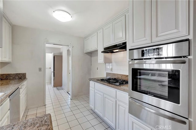 kitchen with a warming drawer, appliances with stainless steel finishes, under cabinet range hood, and white cabinets