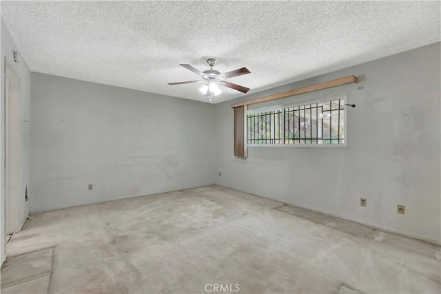 carpeted empty room featuring ceiling fan and a textured ceiling