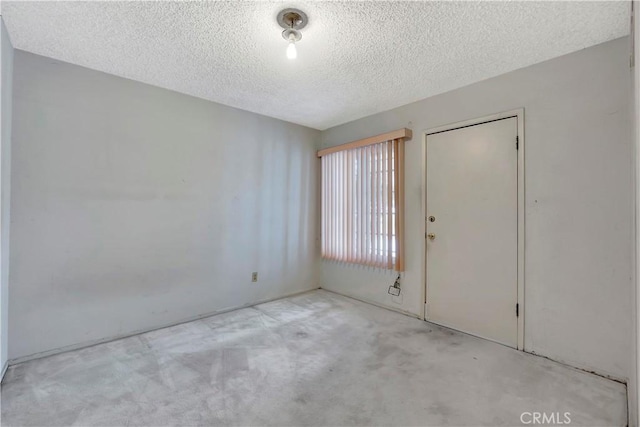 carpeted empty room with a textured ceiling