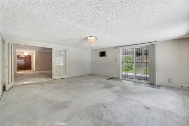 unfurnished room with a textured ceiling and french doors