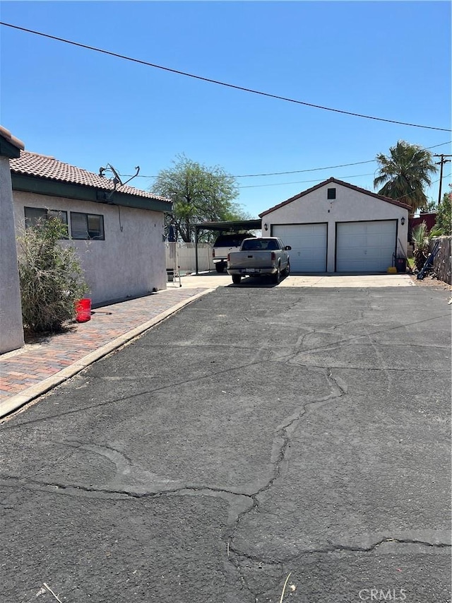 525 S L St, Needles, CA 92363 - view of side of property featuring stucco siding, a detached garage, and an outbuilding