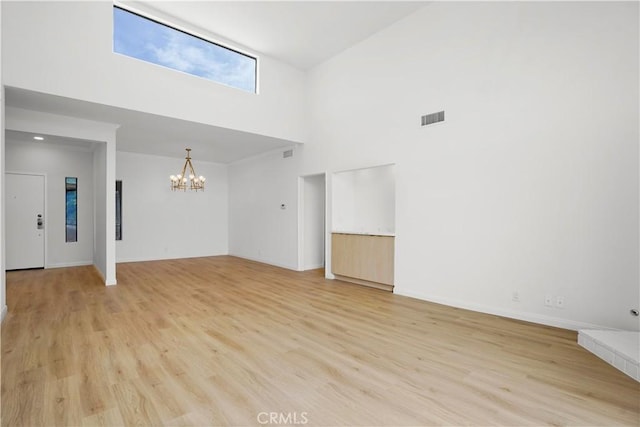14844 Dickens St Unit 306, Sherman Oaks, CA 91403 - spare room featuring a towering ceiling, a chandelier, light wood-style floors, and baseboards