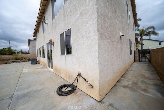 6933 Rio Grande Dr, Eastvale, CA 91752 - view of home's exterior with stucco siding, a patio, and a gate