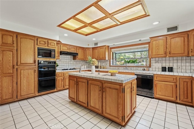 1038 E Meda Ave, Glendora, CA 91741 - kitchen with black appliances, tile countertops, under cabinet range hood, backsplash, and recessed lighting