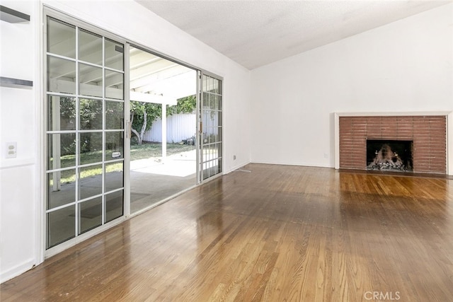 13727 Leadwell St, Van Nuys, CA 91405 - unfurnished living room with wood finished floors, a brick fireplace, and lofted ceiling