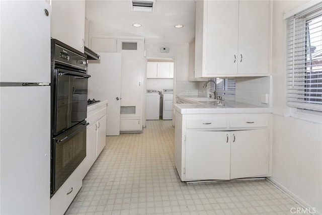 13727 Leadwell St, Van Nuys, CA 91405 - kitchen with light floors, freestanding refrigerator, independent washer and dryer, tile counters, and white cabinetry