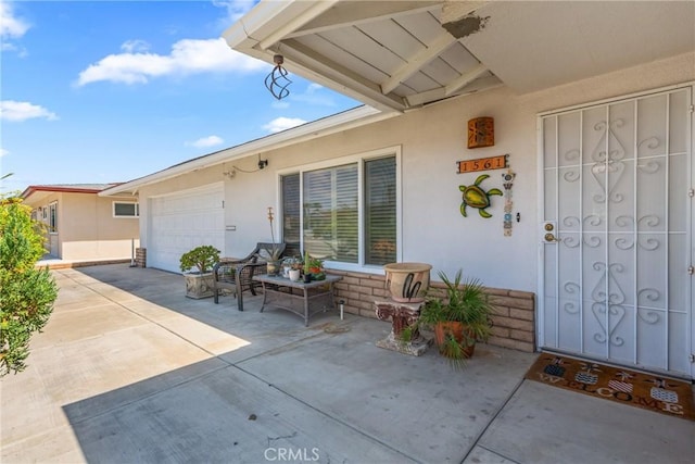 1561 W Wesley Pl, Hemet, CA 92543 - property entrance with an attached garage, concrete driveway, and stucco siding