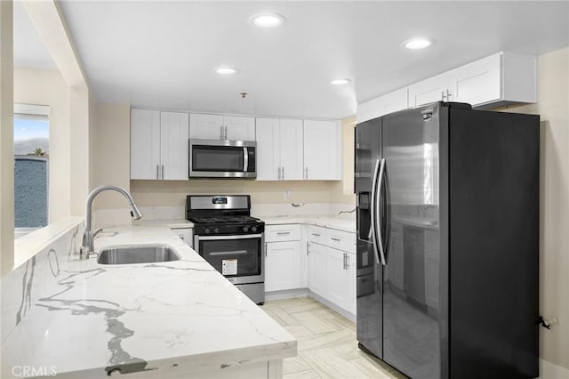 450 W Dryden St Unit 201, Glendale, CA 91202 - kitchen with appliances with stainless steel finishes, a sink, light stone countertops, a peninsula, and white cabinetry