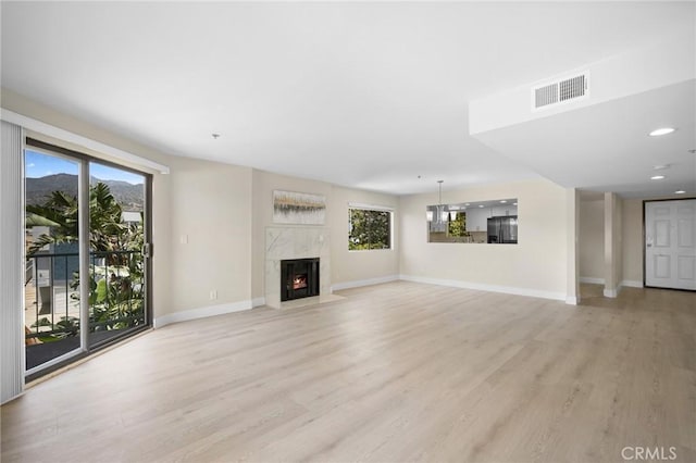 450 W Dryden St Unit 201, Glendale, CA 91202 - unfurnished living room with light wood-type flooring, baseboards, plenty of natural light, a fireplace, and recessed lighting