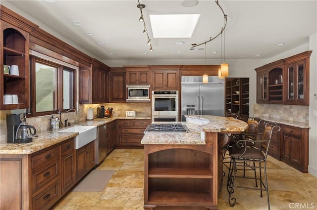 295 Via Piedras Blancas, San Simeon, CA 93452 - kitchen featuring open shelves, built in appliances, a sink, a skylight, and a kitchen island