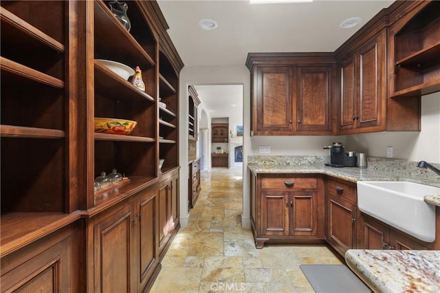 295 Via Piedras Blancas, San Simeon, CA 93452 - kitchen featuring open shelves, stone tile flooring, a sink, and light stone counters