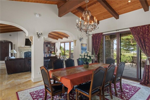 295 Via Piedras Blancas, San Simeon, CA 93452 - dining area featuring wooden ceiling, stone tile floors, arched walkways, a chandelier, and a fireplace