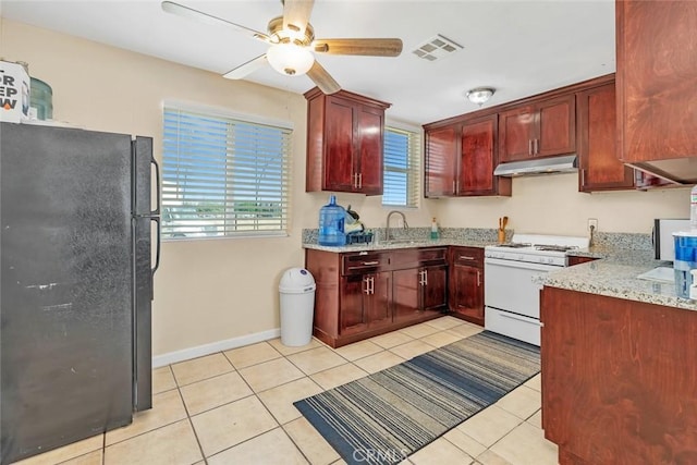 5915 Weedpatch, Bakersfield, CA 93307 - kitchen featuring freestanding refrigerator, white range with gas cooktop, under cabinet range hood, dark brown cabinets, and light tile patterned flooring