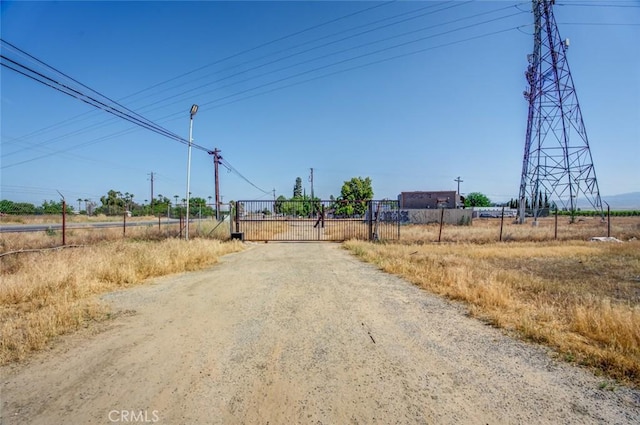 5915 Weedpatch, Bakersfield, CA 93307 - view of dirt / gravel road featuring a gate, a gated entry, and a view of countryside