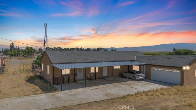 5915 Weedpatch, Bakersfield, CA 93307 - view of front of home featuring an attached garage, a carport, driveway, a mountain view, and stucco siding