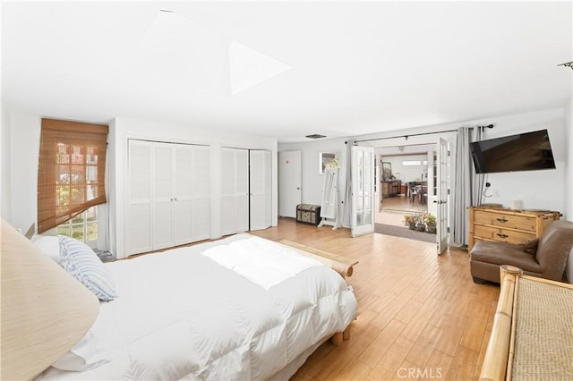 317 Walnut St, Costa Mesa, CA 92627 - bedroom featuring multiple closets, a skylight, light wood-type flooring, and french doors