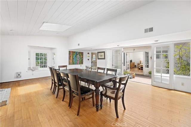 317 Walnut St, Costa Mesa, CA 92627 - dining space featuring a skylight, lofted ceiling, light wood-style flooring, and french doors