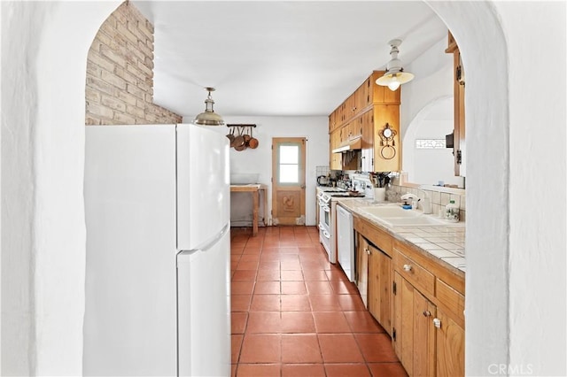 317 Walnut St, Costa Mesa, CA 92627 - kitchen featuring white appliances, tile countertops, under cabinet range hood, arched walkways, and a sink