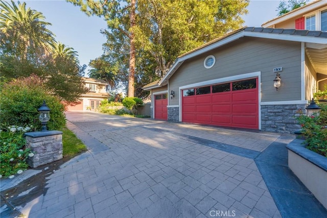 435 S Estate Dr, Orange, CA 92869 - view of home's exterior with an attached garage, stone siding, and decorative driveway