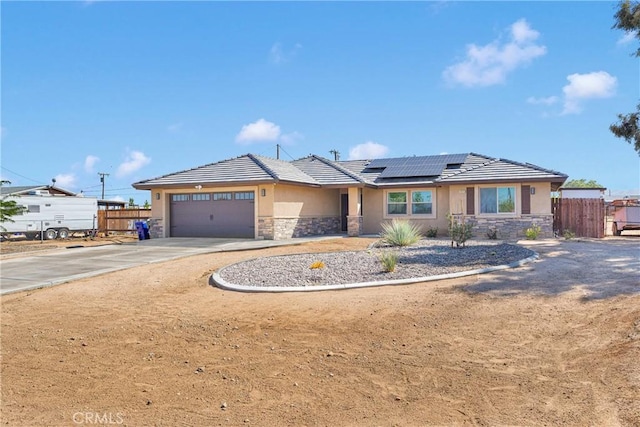 10727 Manhasset Rd, Apple Valley, CA 92308 - view of front of house with stone siding, stucco siding, an attached garage, and roof mounted solar panels
