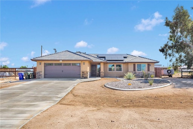 10727 Manhasset Rd, Apple Valley, CA 92308 - view of front facade with stone siding, an attached garage, stucco siding, solar panels, and a tiled roof
