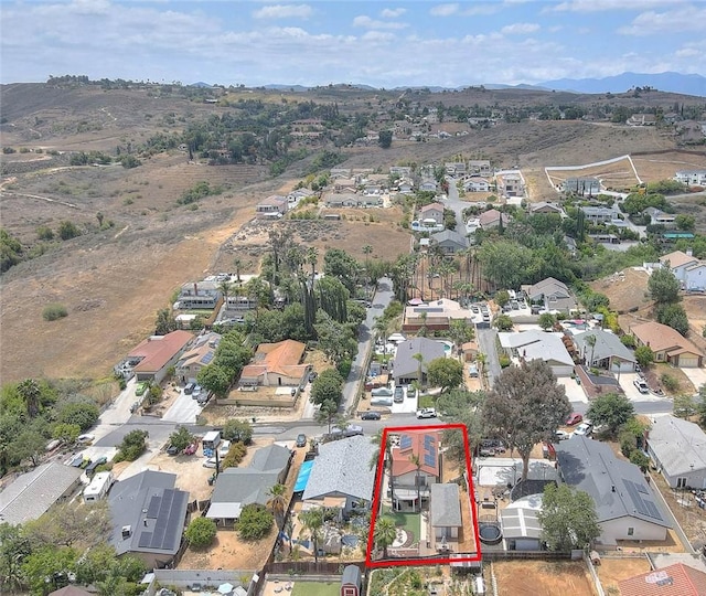 aerial view of property and surrounding area featuring nearby suburban area, property parcel outlined, and a mountain backdrop