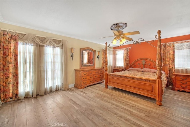 bedroom featuring light wood-style flooring, ornamental molding, and ceiling fan