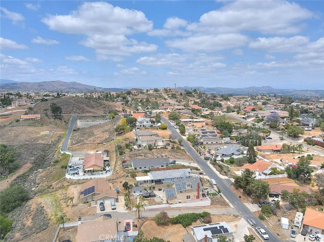 aerial view of property's location featuring nearby suburban area and a mountain backdrop