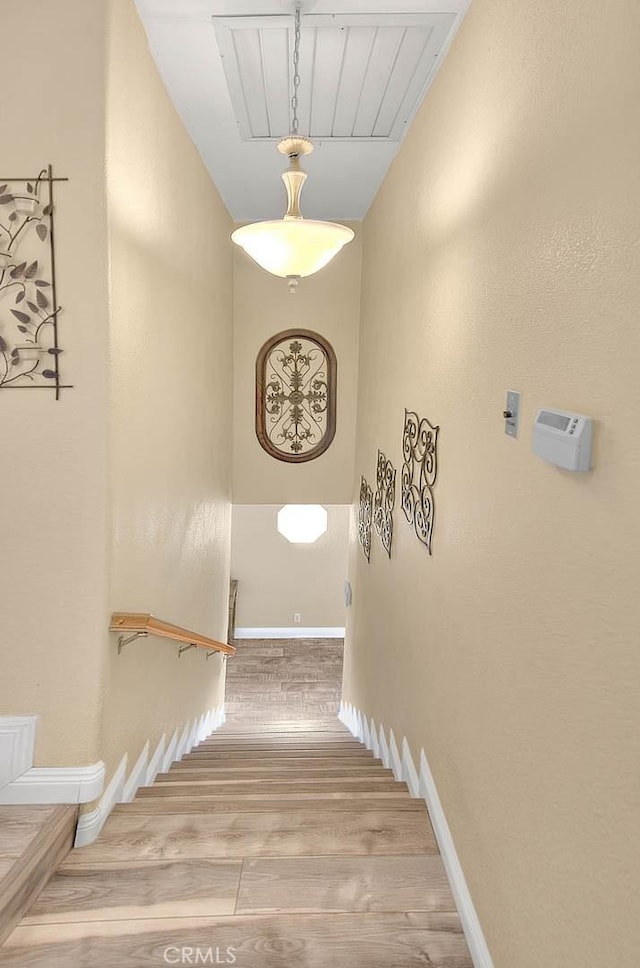 stairs featuring wood finished floors and baseboards