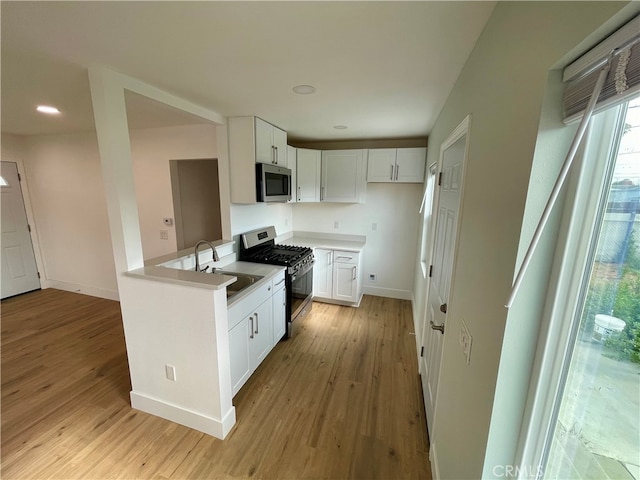 5046 Pacific Ave, Long Beach, CA 90805 - kitchen with stainless steel appliances, a sink, light wood-type flooring, white cabinetry, and recessed lighting