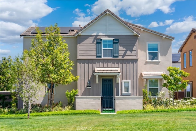 8713 Roving Pl, Chino, CA 91708 - view of front of property with solar panels, a front lawn, and board and batten siding