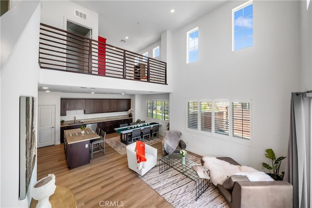 8713 Roving Pl, Chino, CA 91708 - living area featuring light wood-style floors, a towering ceiling, billiards table, and recessed lighting
