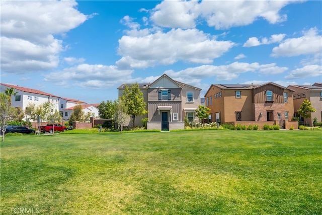8713 Roving Pl, Chino, CA 91708 - back of house with board and batten siding, a lawn, and a residential view