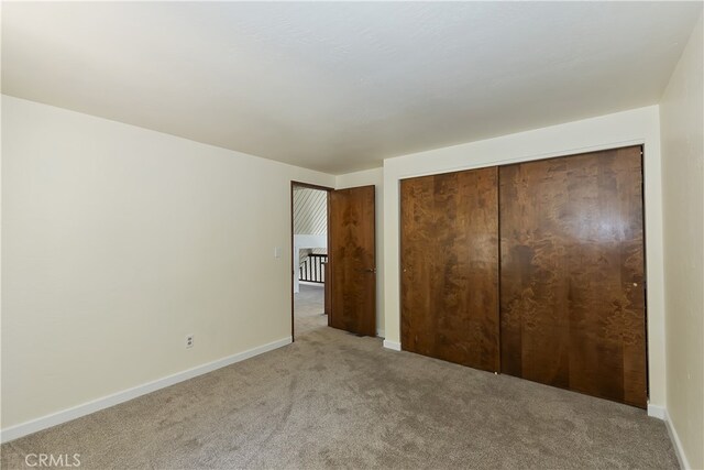 27559 N Bay, Lake Arrowhead, CA 92352 - unfurnished bedroom with light colored carpet, baseboards, and a closet
