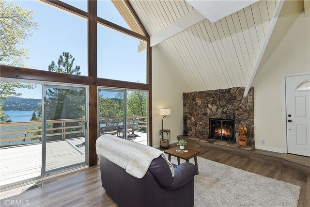 27559 N Bay, Lake Arrowhead, CA 92352 - living area with high vaulted ceiling, wood finished floors, plenty of natural light, a stone fireplace, and baseboards