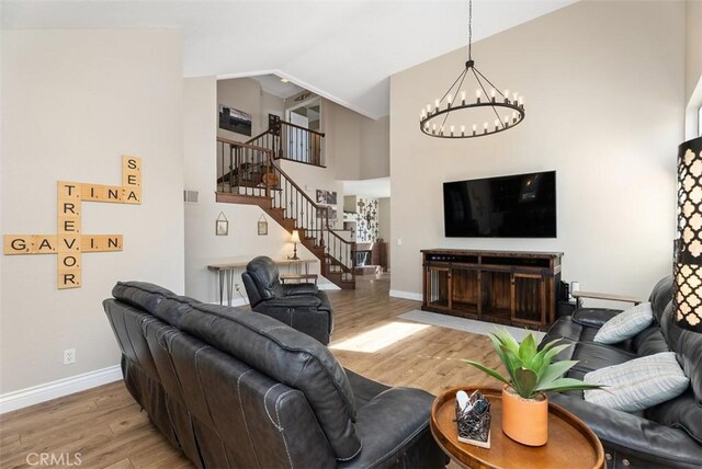 25311 Darlington, Mission Viejo, CA 92692 - living room featuring light wood-style flooring, stairway, a chandelier, baseboards, and high vaulted ceiling