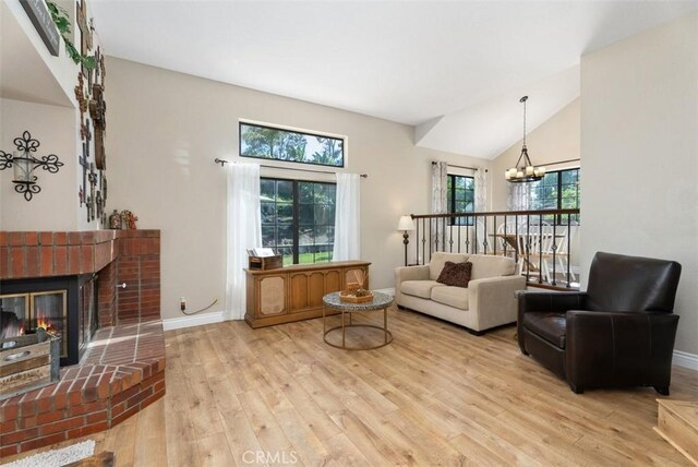 25311 Darlington, Mission Viejo, CA 92692 - living room featuring light wood finished floors, a chandelier, vaulted ceiling, baseboards, and a fireplace