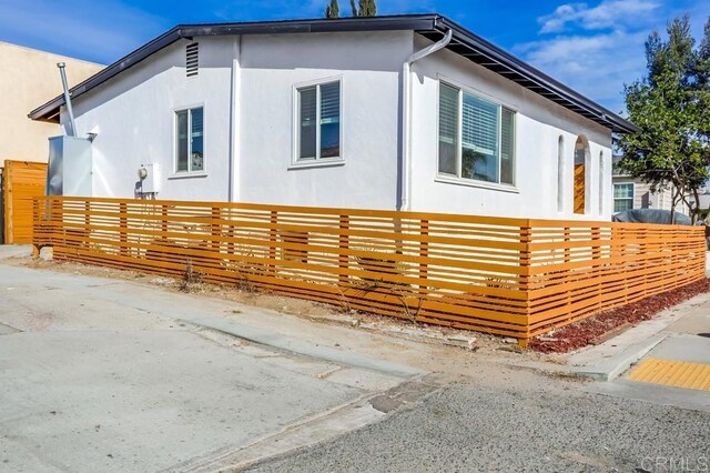 5028 Monroe Ave, San Diego, CA 92115 - view of side of property featuring stucco siding and a fenced front yard