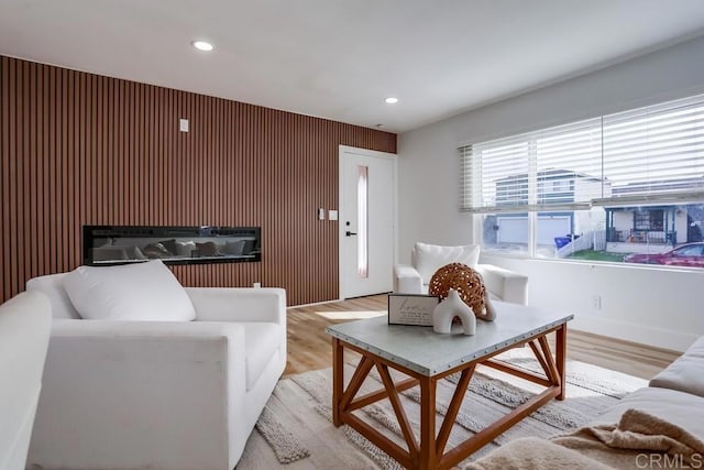 5028 Monroe Ave, San Diego, CA 92115 - living room featuring light wood-style flooring, recessed lighting, an accent wall, and a glass covered fireplace