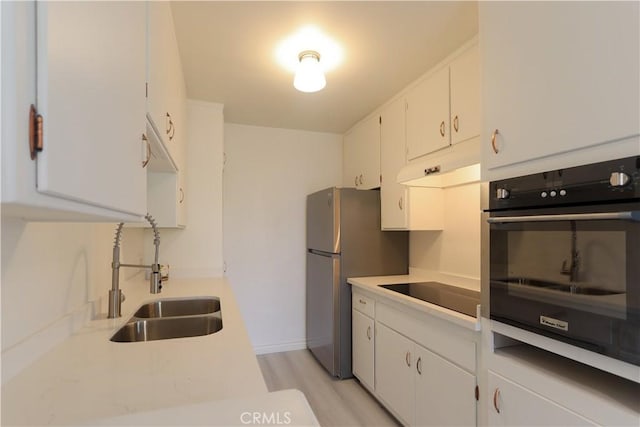 801 E 1st St Unit 17, Long Beach, CA 90802 - kitchen featuring oven, a sink, black electric cooktop, freestanding refrigerator, and under cabinet range hood