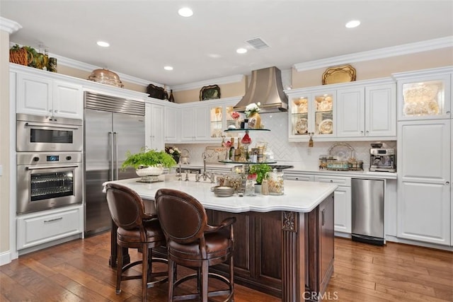 3 Blue Spruce Dr, Ladera Ranch, CA 92694 - kitchen featuring appliances with stainless steel finishes, light countertops, glass insert cabinets, an island with sink, and a kitchen bar
