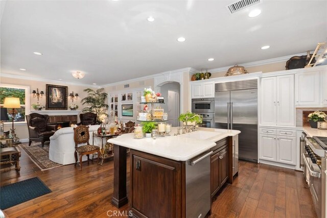 3 Blue Spruce Dr, Ladera Ranch, CA 92694 - kitchen featuring high quality appliances, crown molding, white cabinetry, light countertops, and dark wood-type flooring