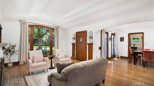2336 N Riverside Dr, Santa Ana, CA 92706 - living area featuring lofted ceiling, arched walkways, plenty of natural light, wood finished floors, and baseboards