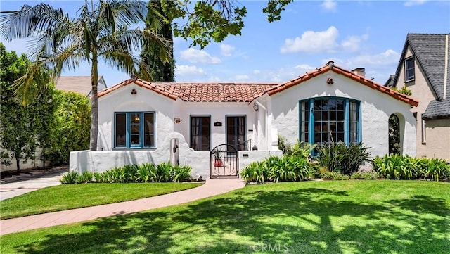 2336 N Riverside Dr, Santa Ana, CA 92706 - mediterranean / spanish-style house with a tile roof, a gate, stucco siding, and a front lawn