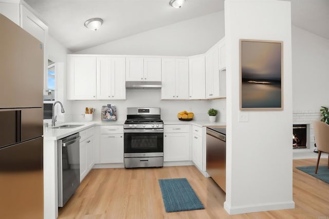 4888 Northerly St, Oceanside, CA 92056 - kitchen with appliances with stainless steel finishes, under cabinet range hood, a sink, light wood finished floors, and vaulted ceiling