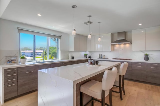 747 S Cedros Ave, Solana Beach, CA 92075 - kitchen with wall chimney exhaust hood, modern cabinets, a sink, a center island, and light wood finished floors