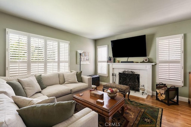 577 S Albertson Ave, Covina, CA 91723 - living area featuring a brick fireplace, wood finished floors, and baseboards