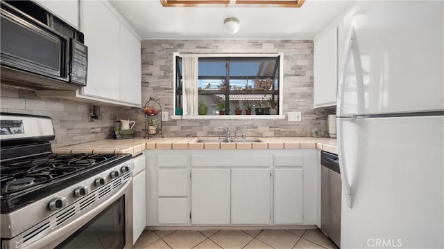 3458 Santa Barbara Ct, Palmdale, CA 93550 - kitchen featuring appliances with stainless steel finishes, a sink, tile counters, and white cabinetry