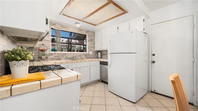 3458 Santa Barbara Ct, Palmdale, CA 93550 - kitchen with freestanding refrigerator, tile countertops, stainless steel dishwasher, decorative backsplash, and white cabinets