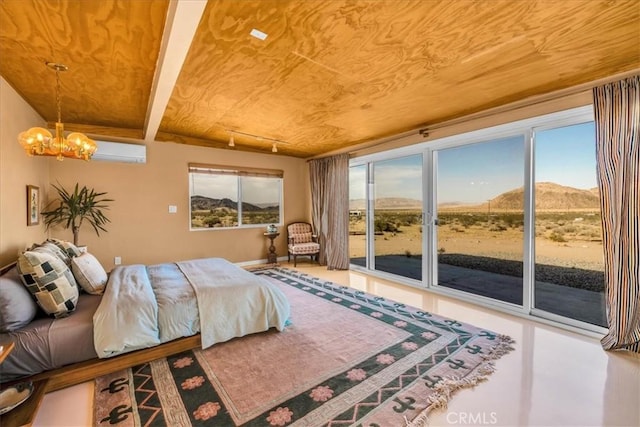 4171 Hughes Ln, Landers, CA 92285 - bedroom featuring access to outside, a chandelier, a wall mounted air conditioner, and a mountain view